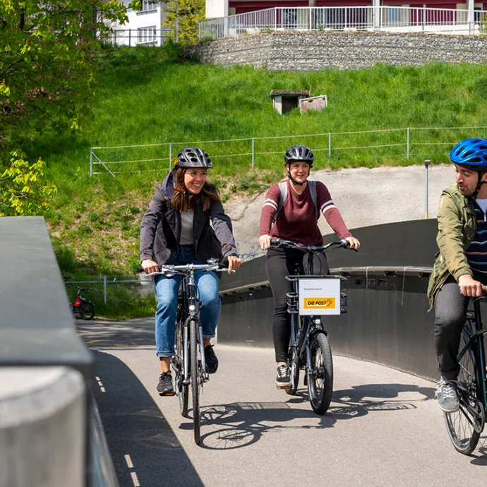 3 personnes à vélo sur un pont cyclable